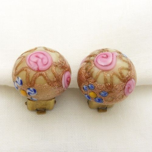 A pair of circular Italian wedding cake glass clip-on earrings featuring cream bases adorned with gold aventurine swirls and applied pink glass roses. View III
