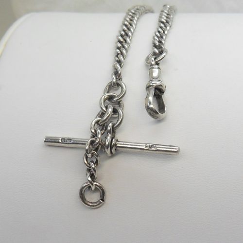 A sterling silver heavy curb link pocket watch chain featuring a T-bar attachment and swivel clasp laid across a surface. View II