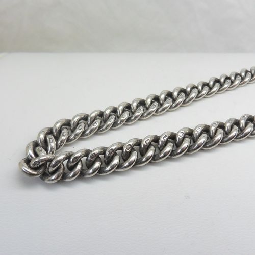 A sterling silver heavy curb link pocket watch chain featuring a T-bar attachment and swivel clasp laid across a surface. View III