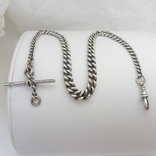 A sterling silver heavy curb link pocket watch chain featuring a T-bar attachment and swivel clasp laid across a surface. View IV
