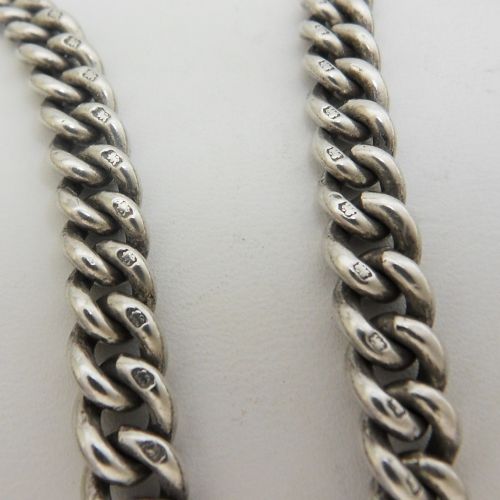 A sterling silver heavy curb link pocket watch chain featuring a T-bar attachment and swivel clasp laid across a surface. View V