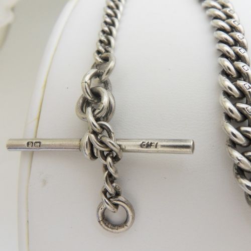 A sterling silver heavy curb link pocket watch chain featuring a T-bar attachment and swivel clasp laid across a surface. View VI