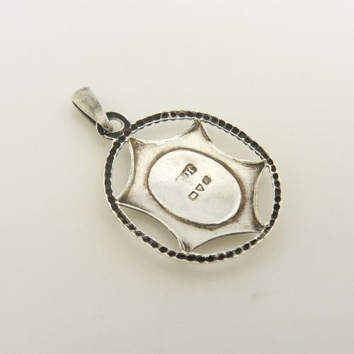 fig 1. An antique sterling silver pendant containing a white guilloche enamel oval decorated with a painted pink rose, enclosed within a star-shaped silver motif and beaded circular outer border.