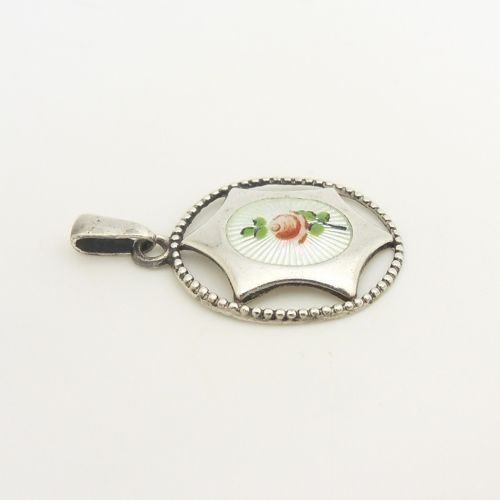 An antique sterling silver pendant containing a white guilloche enamel oval decorated with a painted pink rose, enclosed within a star-shaped silver motif and beaded circular outer border. View IV