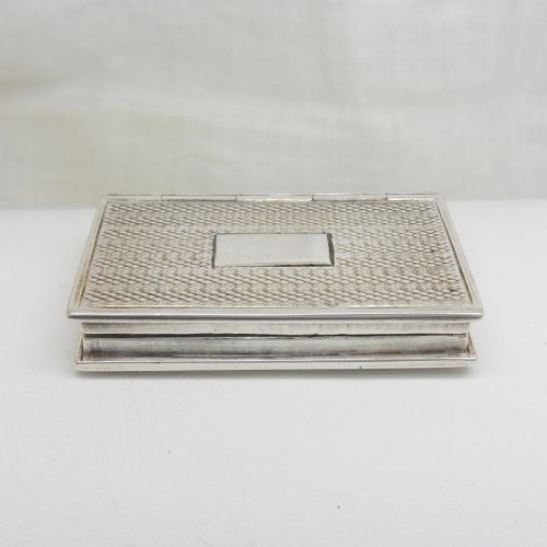 fig 2. An antique sterling silver vinaigrette crafted in the form of a miniature book with an engine-turned cover, rectangular cartouche, and ribbed spine.