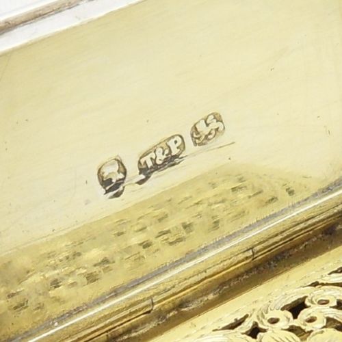 An antique sterling silver vinaigrette crafted in the form of a miniature book with an engine-turned cover, rectangular cartouche, and ribbed spine. View V