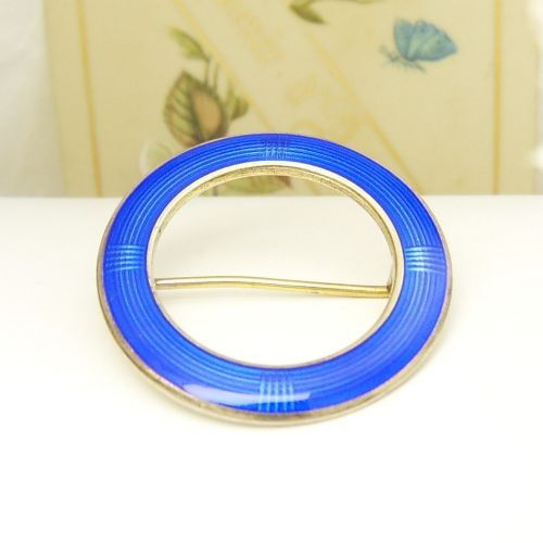 A circular Norwegian brooch crafted in silver with vibrant cobalt blue guilloche enamel and fine geometric line patterns. View III
