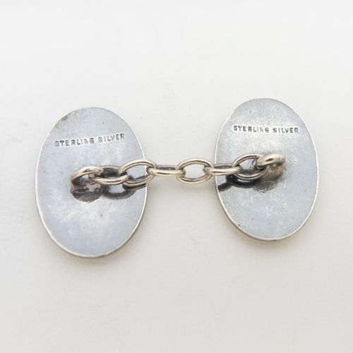 A pair of oval sterling silver Art Deco cufflinks featuring vertical black and yellow enamel stripes connected by silver chain links. View V