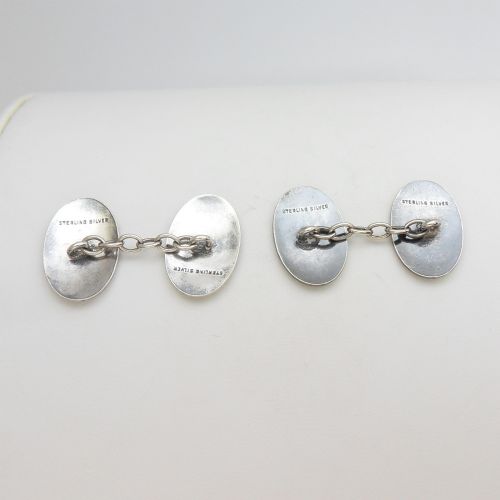 A pair of oval sterling silver Art Deco cufflinks featuring vertical black and yellow enamel stripes connected by silver chain links. View VI