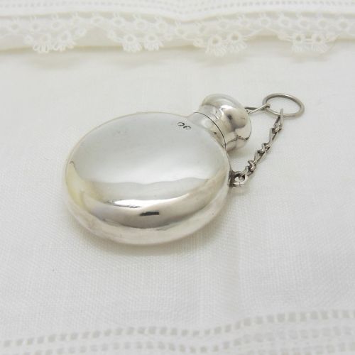 fig 2. A round Victorian sterling silver miniature scent flask with a suspension chain and stamped hallmarks.