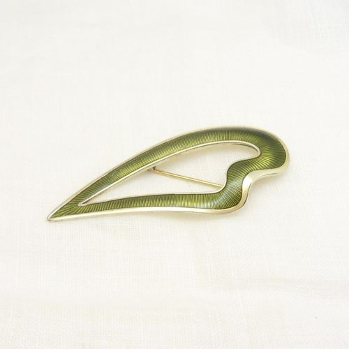 An asymmetric leaf-shaped brooch decorated with green guilloche enamel set within a gilded sterling silver frame. View IV
