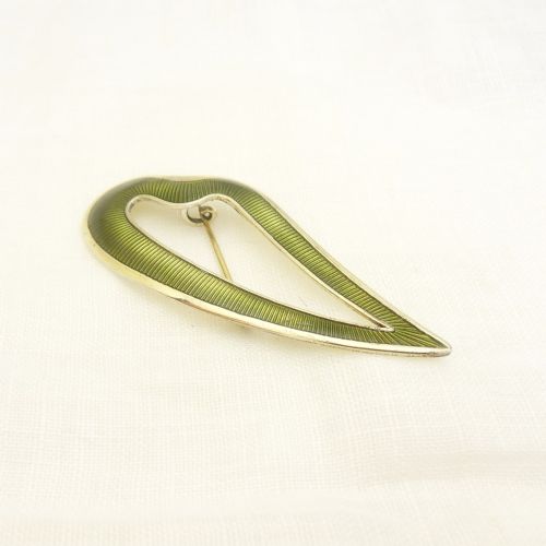 An asymmetric leaf-shaped brooch decorated with green guilloche enamel set within a gilded sterling silver frame. View VI