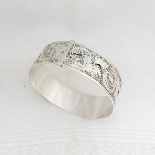 fig 1. A sterling silver buckle bangle bracelet decorated with scrollwork engraving and hallmarked silversmith details.