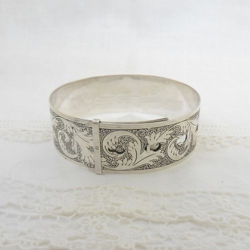 A sterling silver buckle bangle bracelet decorated with scrollwork engraving and hallmarked silversmith details. View III