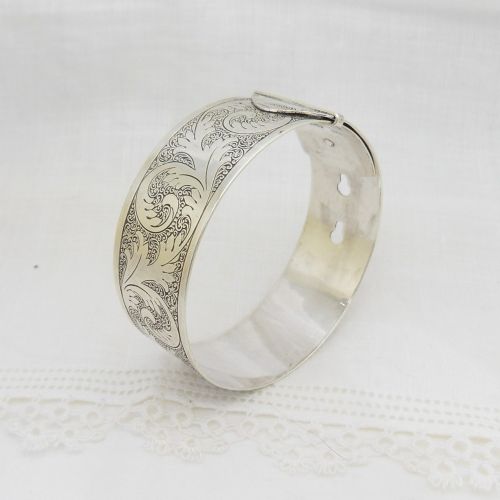 A sterling silver buckle bangle bracelet decorated with scrollwork engraving and hallmarked silversmith details. View IV