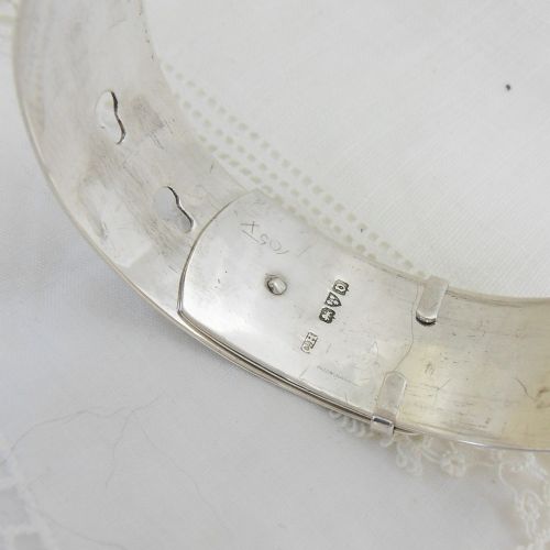 A sterling silver buckle bangle bracelet decorated with scrollwork engraving and hallmarked silversmith details. View V
