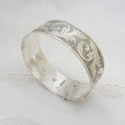 A sterling silver buckle bangle bracelet decorated with scrollwork engraving and hallmarked silversmith details. View VI