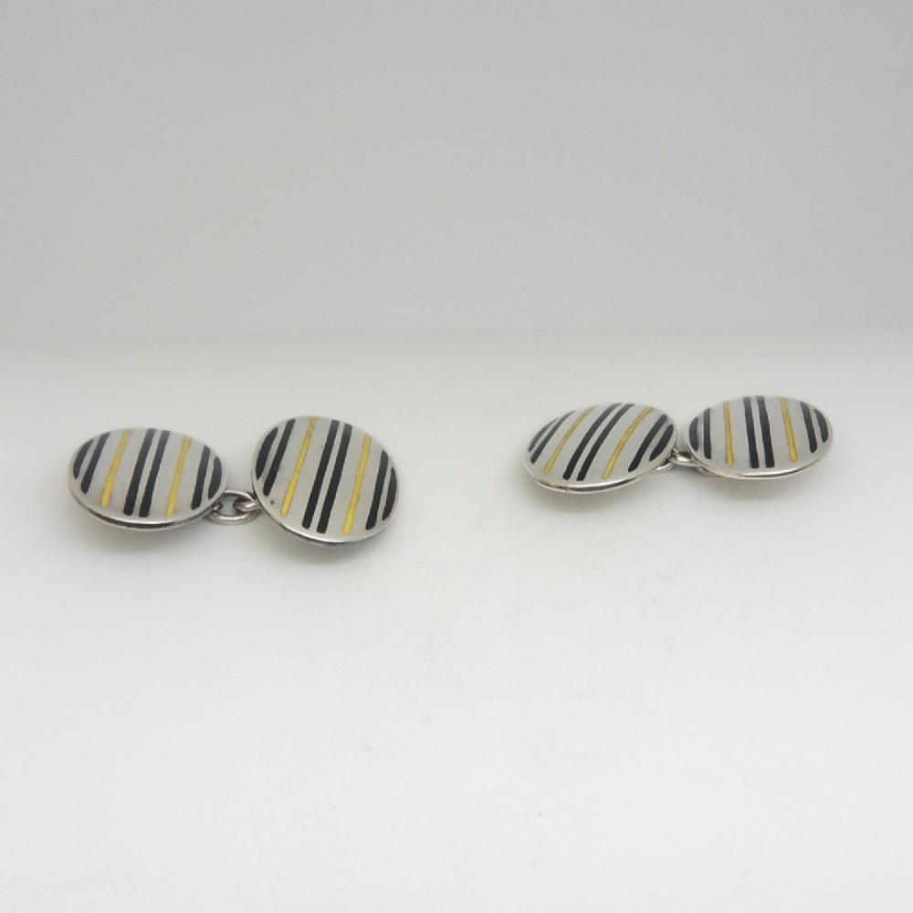 A pair of oval sterling silver Art Deco cufflinks featuring vertical black and yellow enamel stripes connected by silver chain links. View III