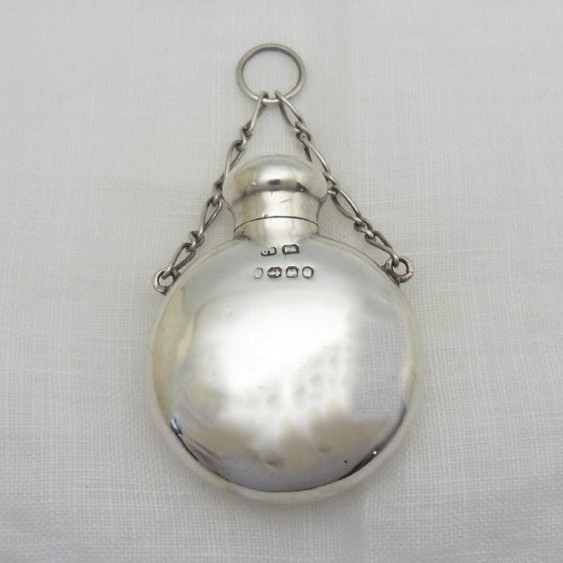A round Victorian sterling silver miniature scent flask with a suspension chain and stamped hallmarks. View VI