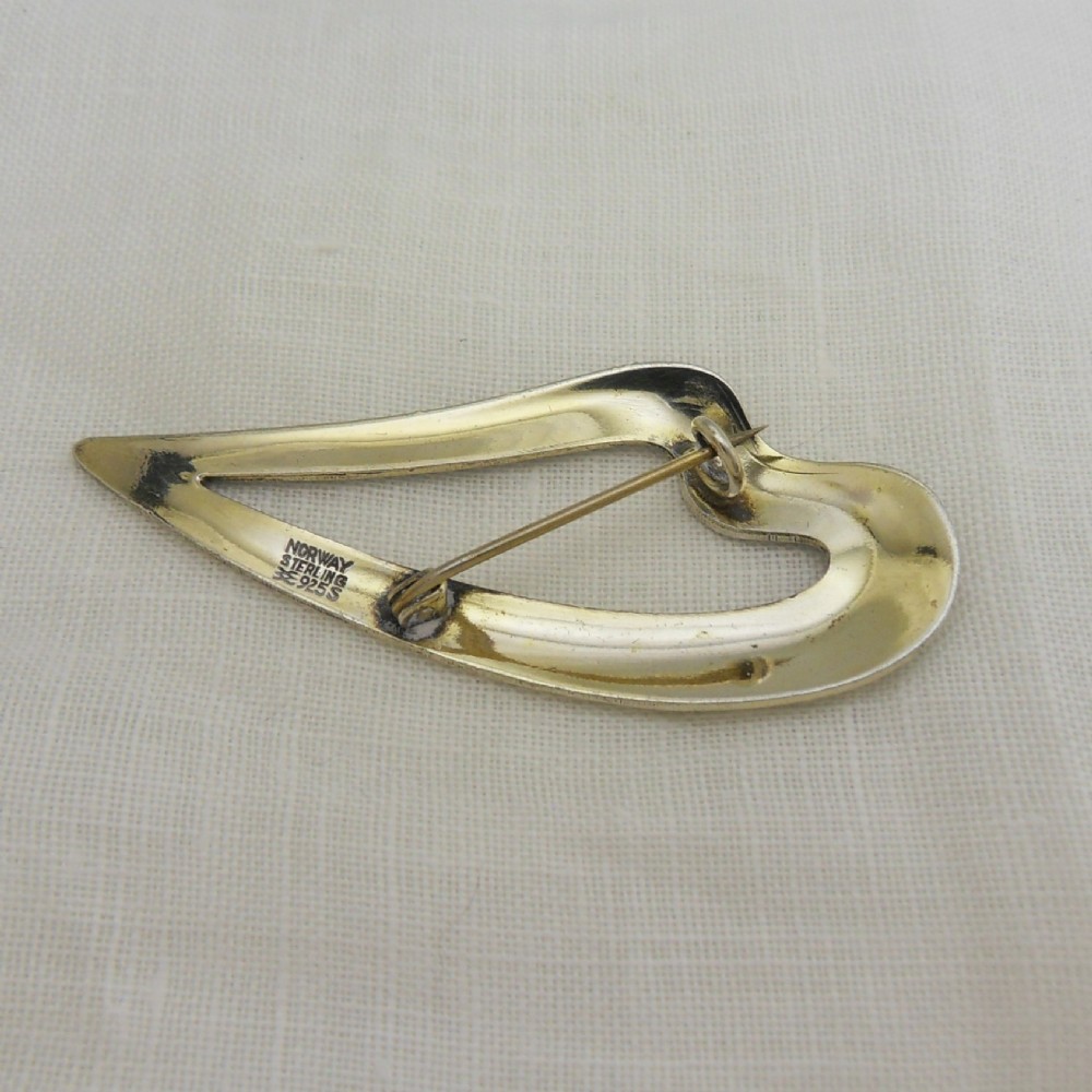 An asymmetric leaf-shaped brooch decorated with green guilloche enamel set within a gilded sterling silver frame. View III