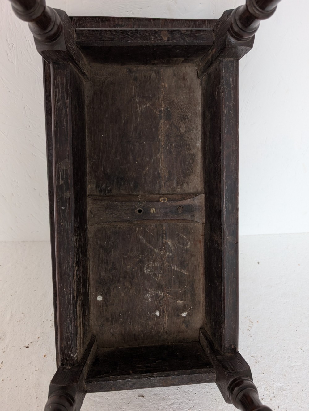 An 18th-century dark oak joint stool featuring turned legs, pegged mortise and tenon joints, and a rectangular top with low stretchers. View III