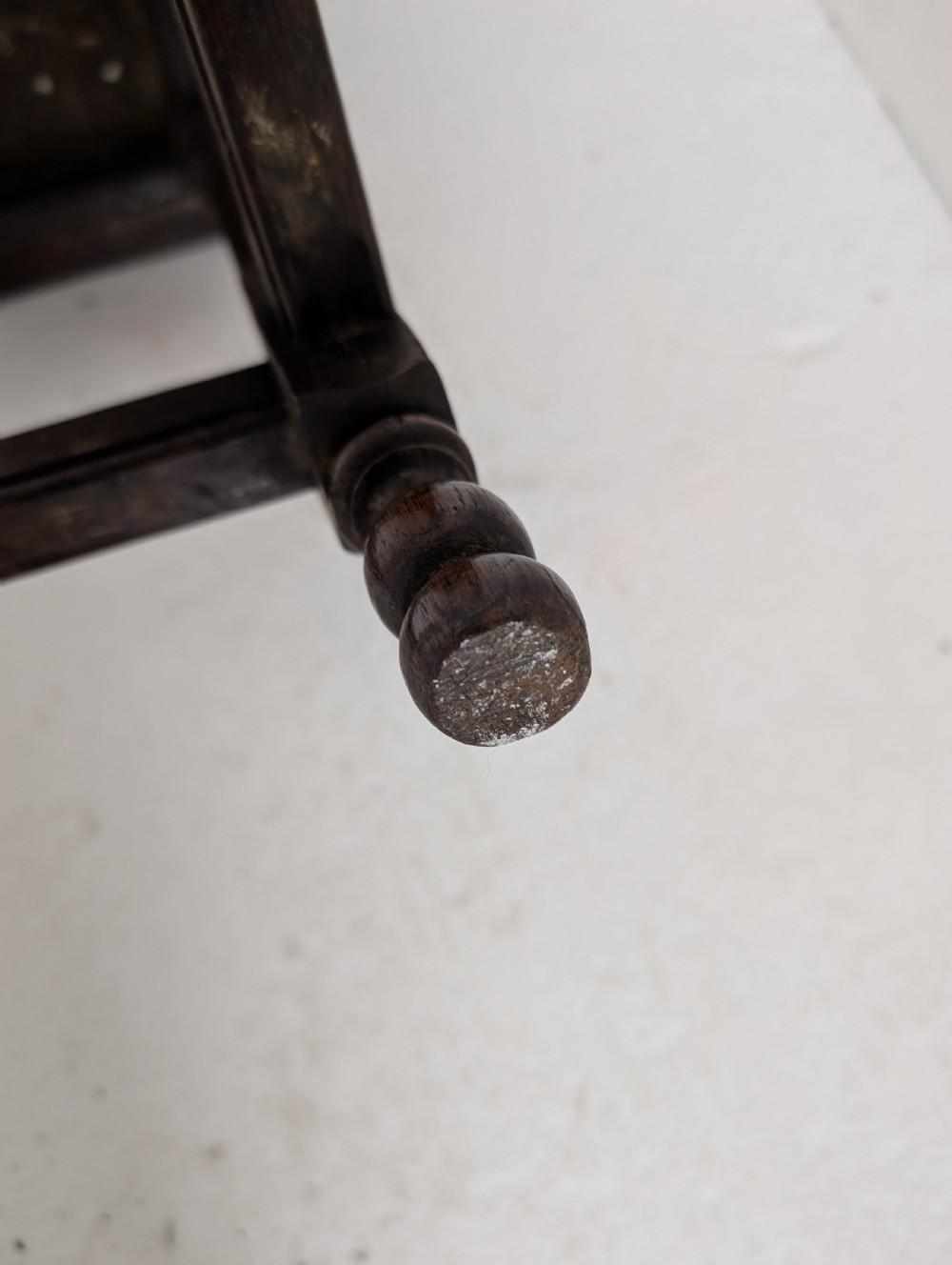 An 18th-century dark oak joint stool featuring turned legs, pegged mortise and tenon joints, and a rectangular top with low stretchers. View VI