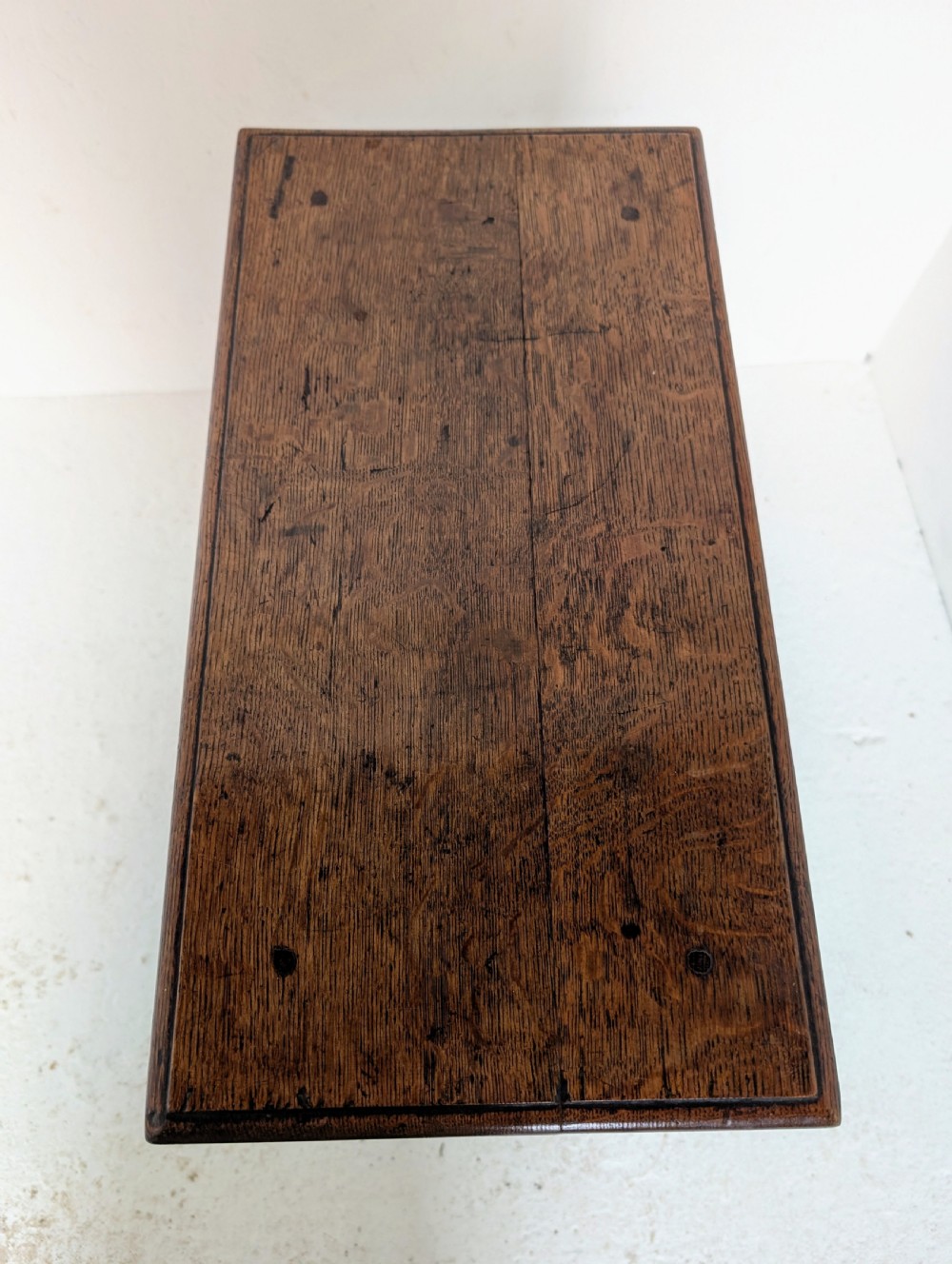 An 18th-century dark oak joint stool featuring turned legs, pegged mortise and tenon joints, and a rectangular top with low stretchers. View XII