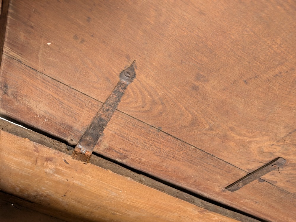 A dark oak 17th-century coffer featuring geometric hand-carved details across the front, an iron lock plate, and stile feet. View IV