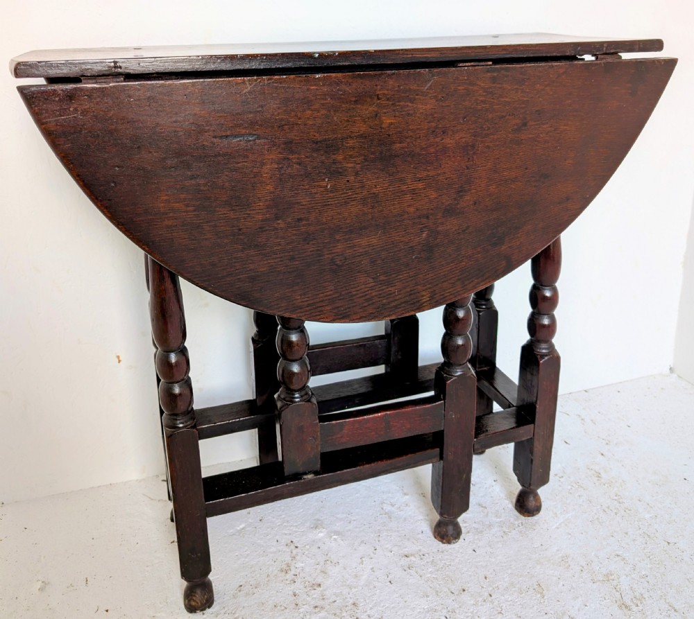 A dark oak 17th-century gateleg table with two drop-leaf flaps, turned baluster legs, and low box stretchers. View III