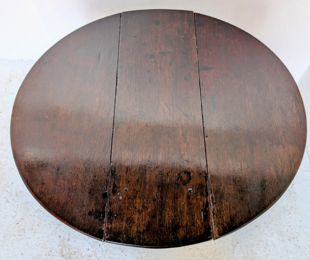 A dark oak 17th-century gateleg table with two drop-leaf flaps, turned baluster legs, and low box stretchers. View VII