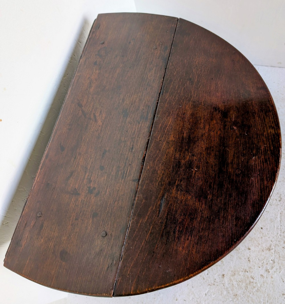 A dark oak 17th-century gateleg table with two drop-leaf flaps, turned baluster legs, and low box stretchers. View X