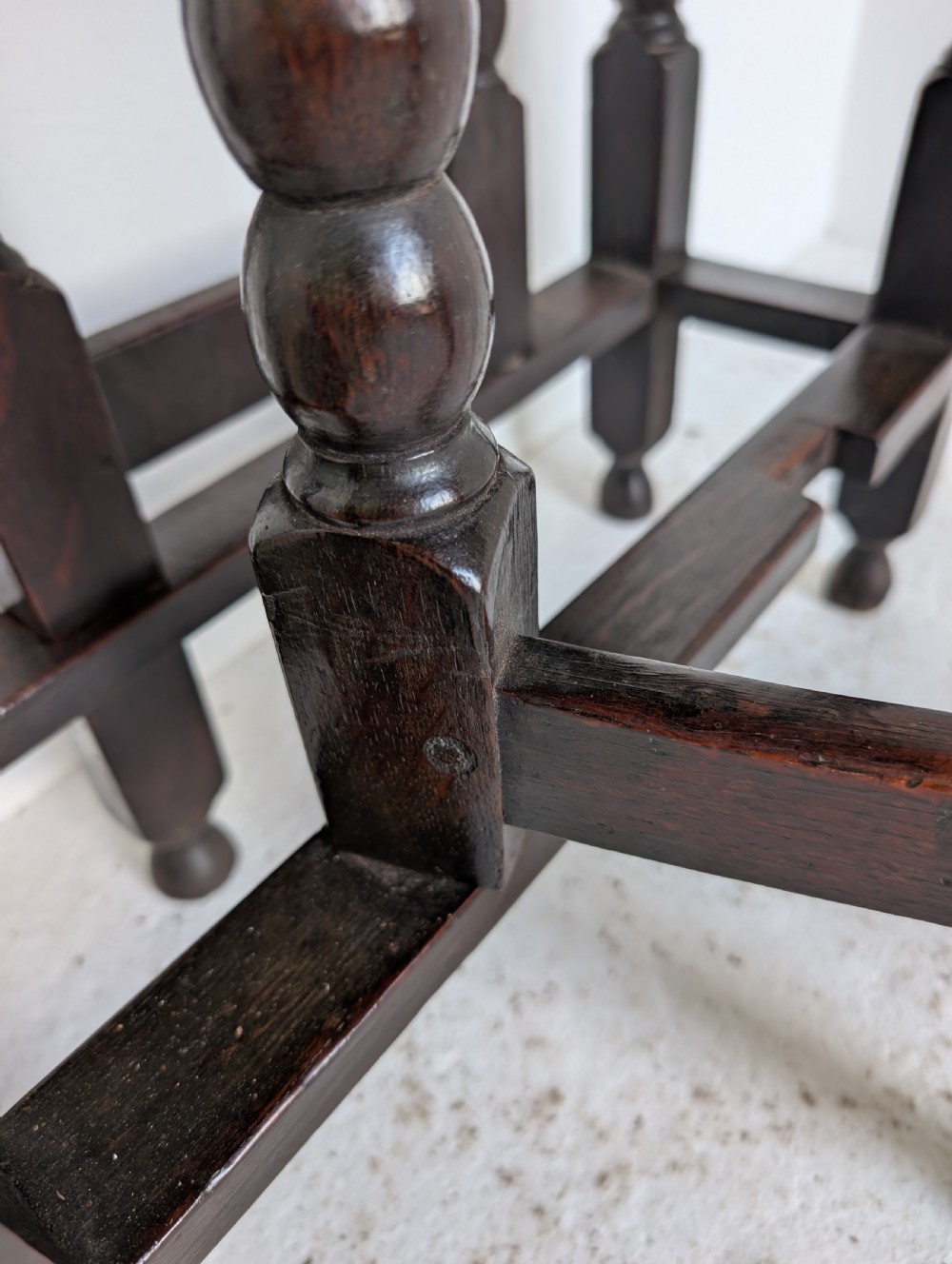 A dark oak 17th-century gateleg table with two drop-leaf flaps, turned baluster legs, and low box stretchers. View XIV