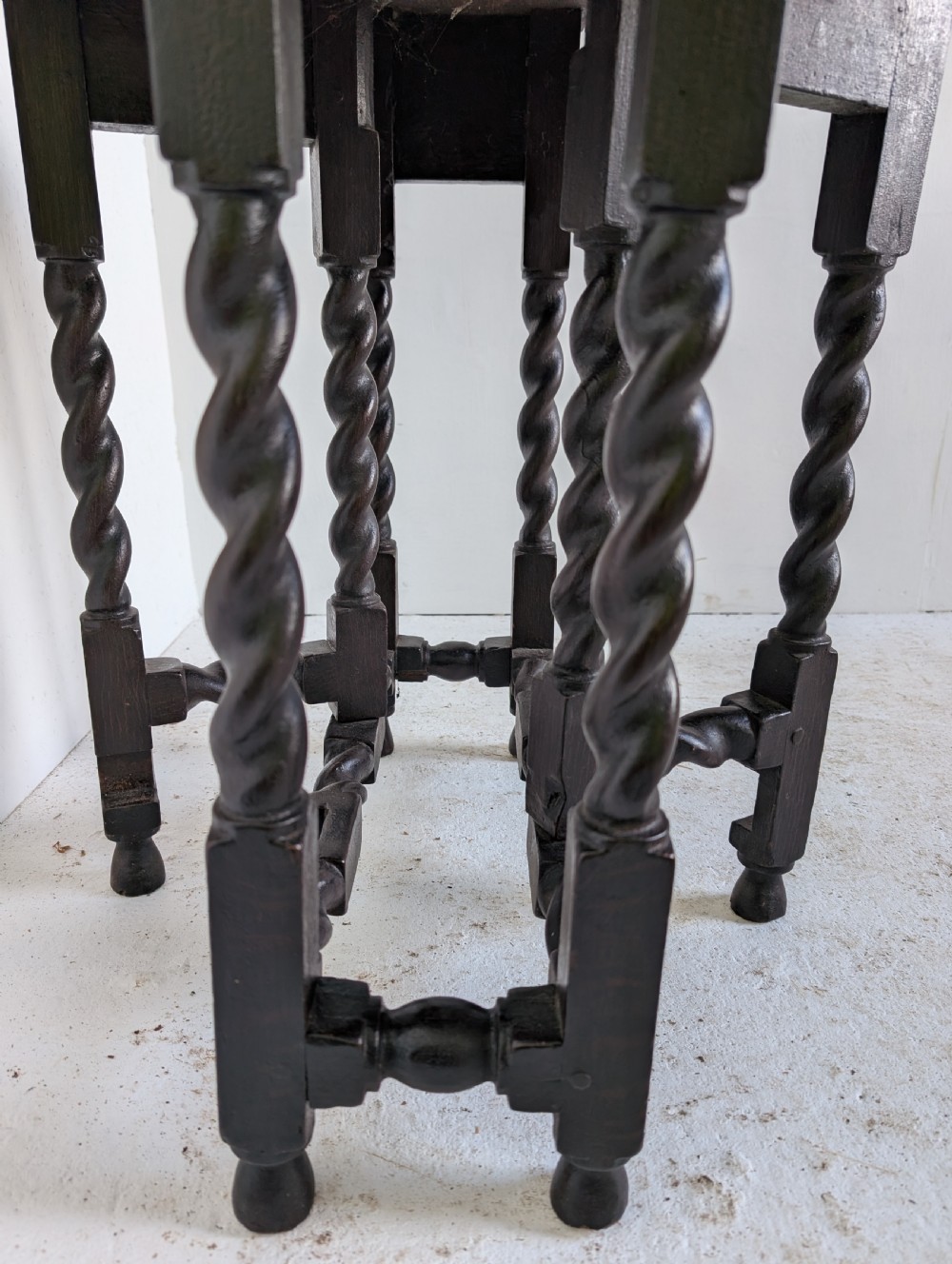 A small dark oak gateleg table featuring a drop-leaf top, barley twist legs, and lower connecting stretchers. View III