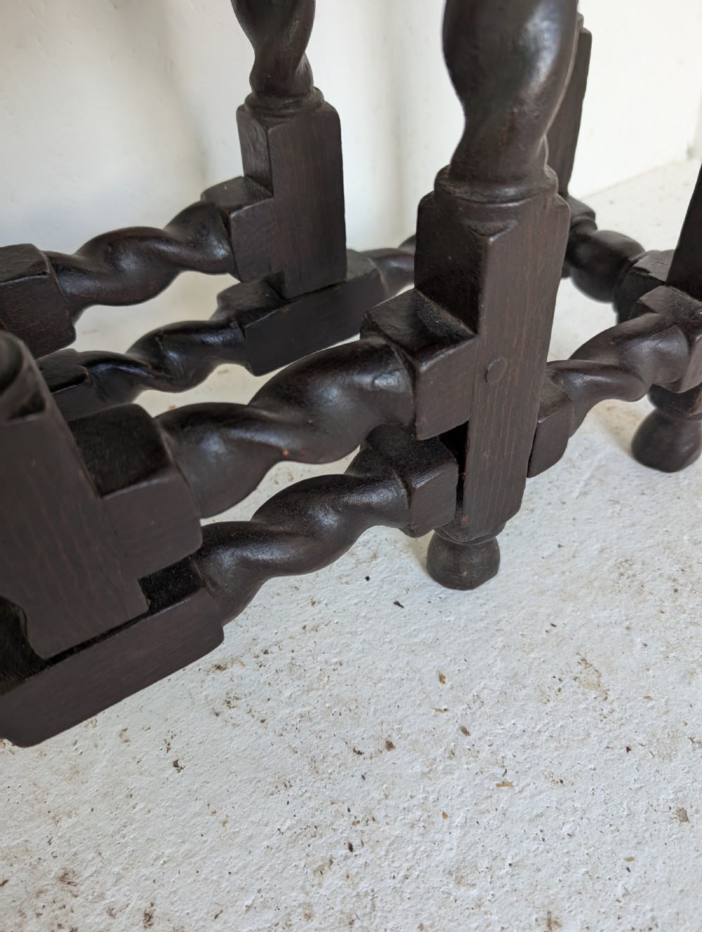 A small dark oak gateleg table featuring a drop-leaf top, barley twist legs, and lower connecting stretchers. View V