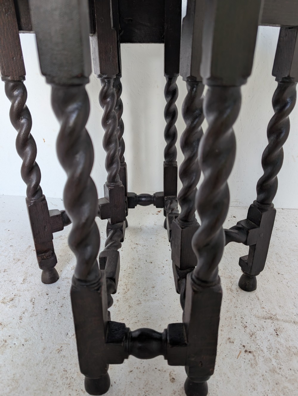 A small dark oak gateleg table featuring a drop-leaf top, barley twist legs, and lower connecting stretchers. View X