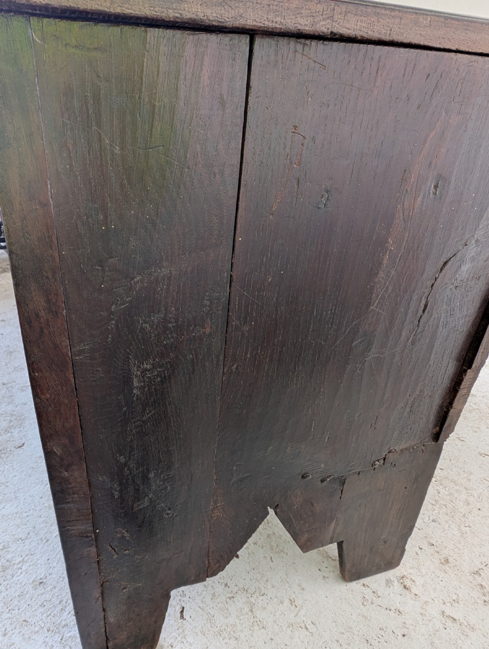 A dark brown 17th century oak coffer featuring three carved panel fronts with circular rosette motifs and a hinged lid. View III