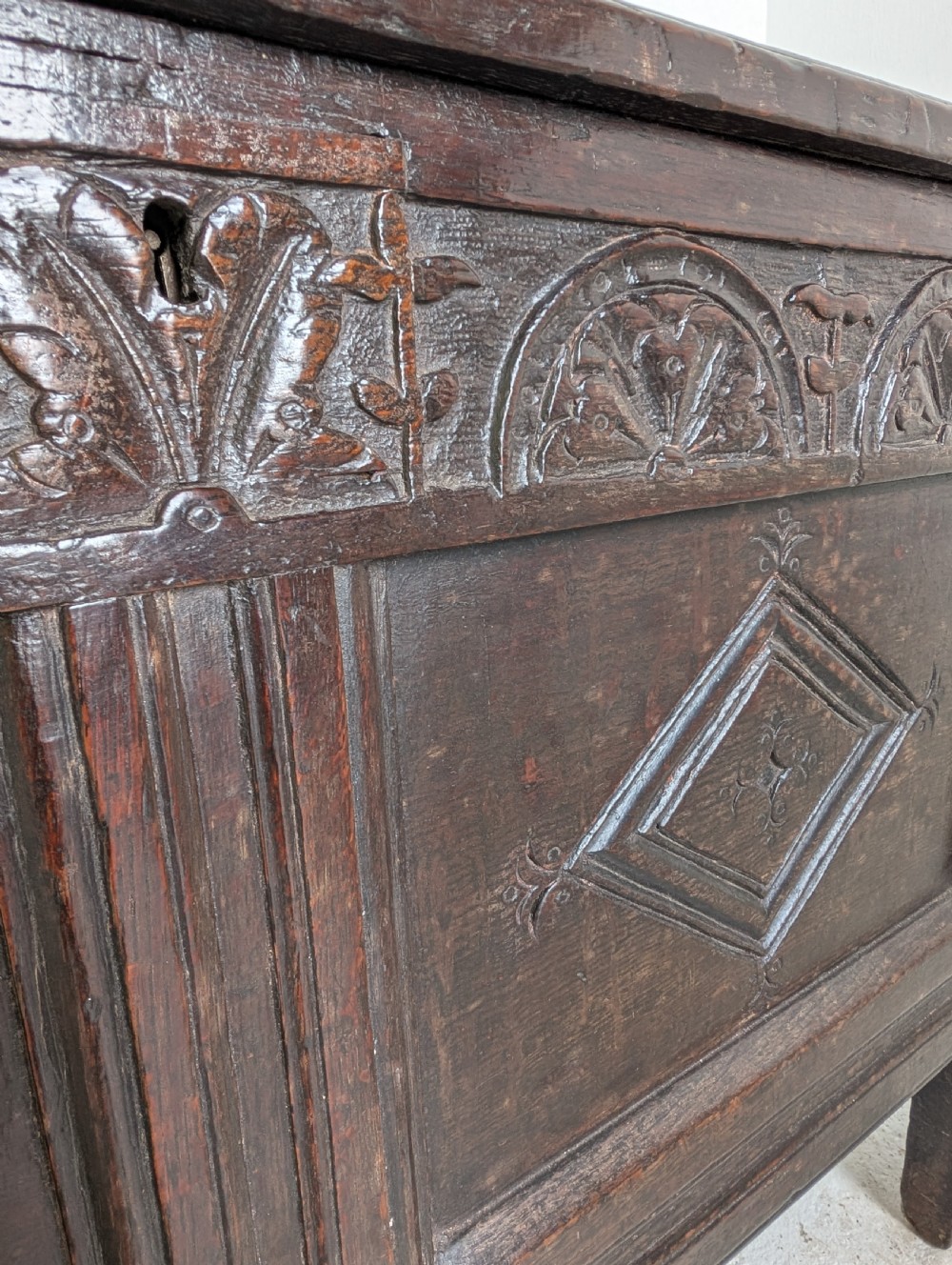 A 17th-century dark oak coffer featuring lunette carving on the upper rail and lozenge panel detailing across the front. View II