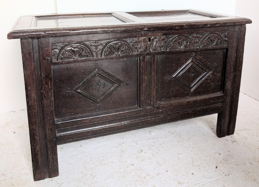 A 17th-century dark oak coffer featuring lunette carving on the upper rail and lozenge panel detailing across the front. View III