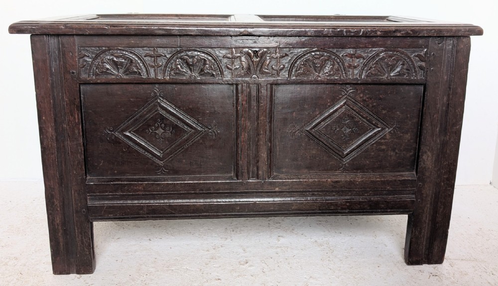 A 17th-century dark oak coffer featuring lunette carving on the upper rail and lozenge panel detailing across the front. View IV
