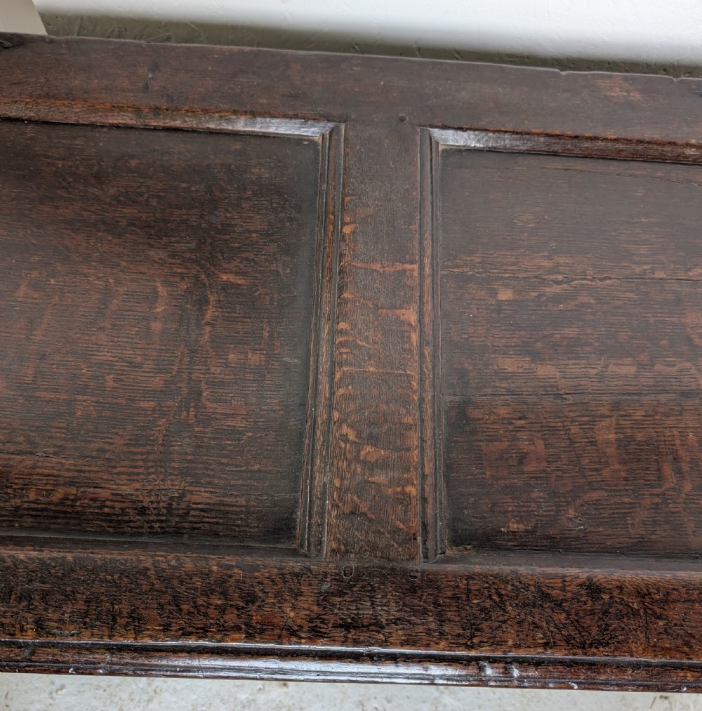 A 17th-century dark oak coffer featuring lunette carving on the upper rail and lozenge panel detailing across the front. View VII