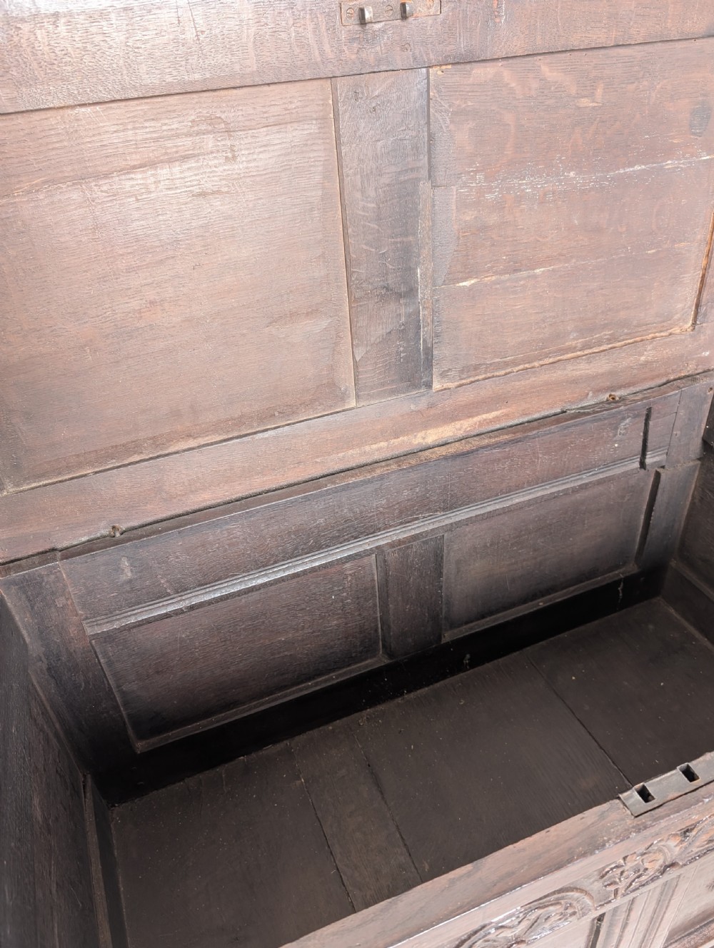 A 17th-century dark oak coffer featuring lunette carving on the upper rail and lozenge panel detailing across the front. View VIII