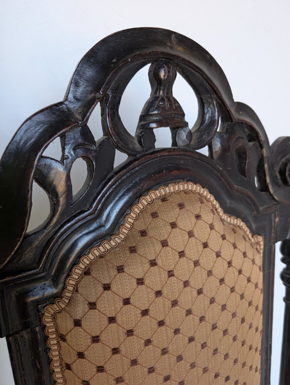 A late 17th-century William and Mary dark oak armchair featuring a tall carved crest rail, an upholstered back and seat in patterned fabric, and elaborate scrollwork stretchers. View III