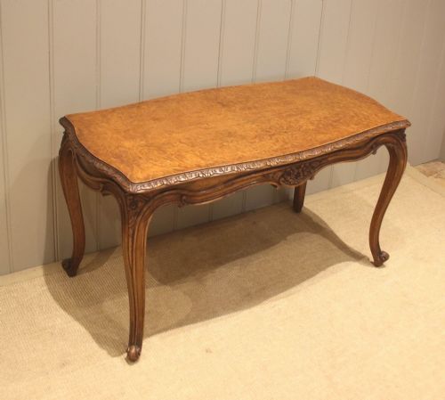 fig 1. A low rectangular burr walnut coffee table with a serpentine top, hand-carved floral apron, and curved cabriole legs.