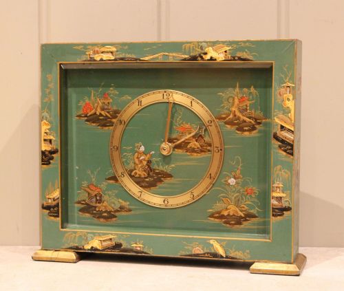 fig 1. A rectangular green lacquered mantel clock decorated with gilded Chinoiserie scenes and a central brass dial.