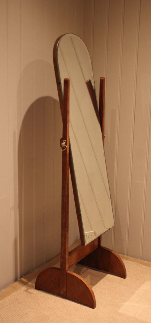 An Art Deco freestanding walnut cheval mirror featuring an arched glass plate set within a timber stand. View IX