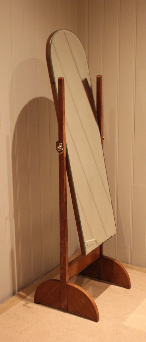 An Art Deco freestanding walnut cheval mirror featuring an arched glass plate set within a timber stand. View XII