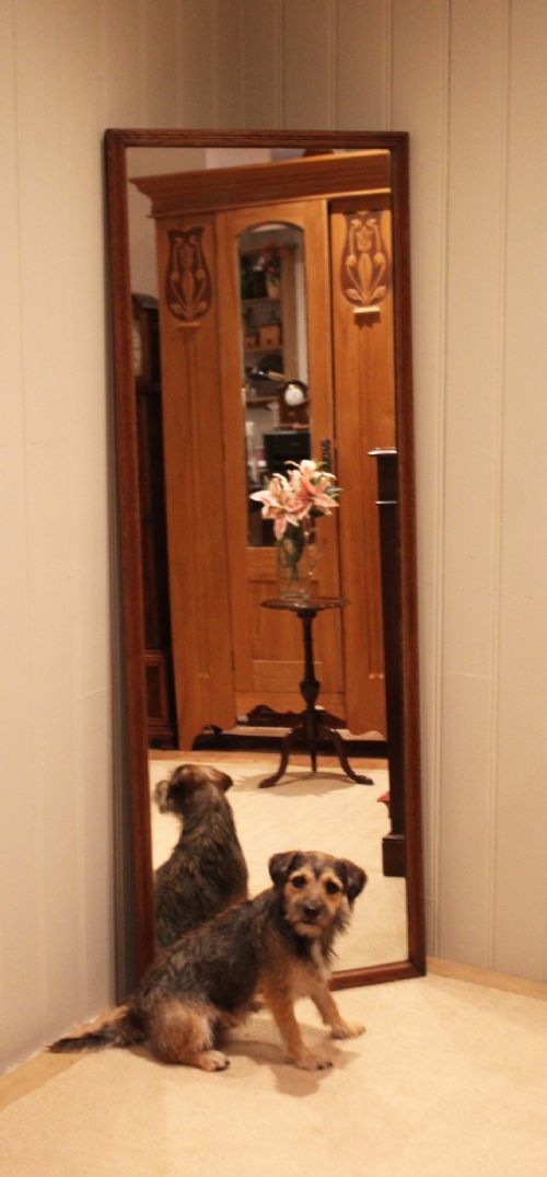 A large rectangular full-length mirror featuring a slender moulded oak frame with visible natural grain. View VII