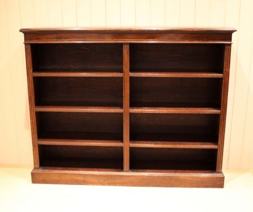 fig 1. A double-bay open oak library bookcase featuring fluted pilasters, multiple horizontal shelves, a moulded top edge, and a solid plinth base.