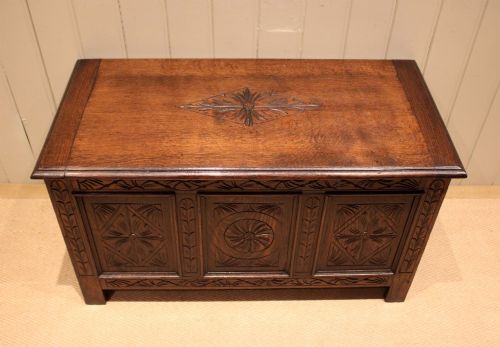 fig 1. A rectangular dark oak storage coffer featuring three hand-carved front panels with rosette and geometric motifs.