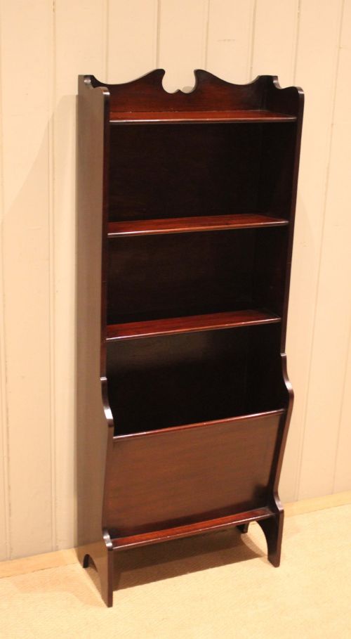 fig 1. A narrow dark mahogany floor-standing shelf featuring two open upper book shelves and an angled lower magazine trough with a shaped top gallery.